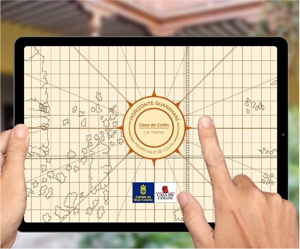 Un par de manos sostienen una tableta negra en la que se muestra un mapa titulado "Horizonte Guaiamar; Casa de Colón a Los Palmeros". Los logotipos del "Cabildo de Gran Canaria" y de la "Casa de Colón" aparecen en la parte inferior de la pantalla. El fondo está borroso.